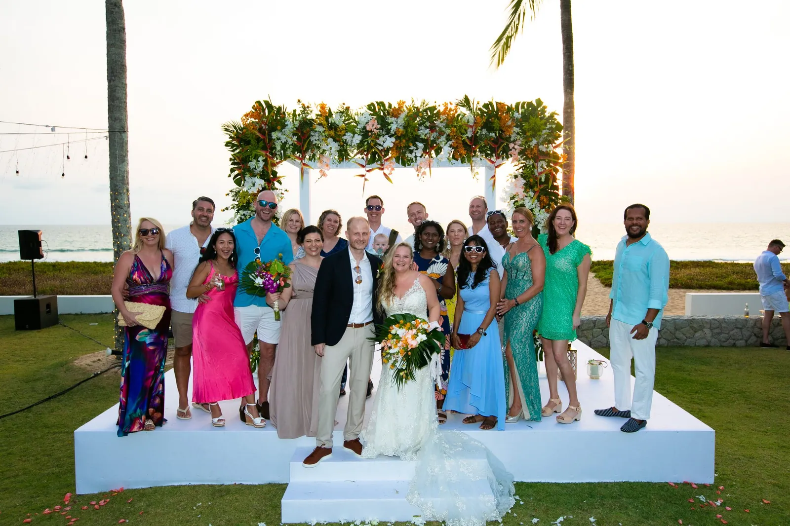 Bekki and Glen with their full wedding party under the floral arch at Villa Jia, Natai Beach
