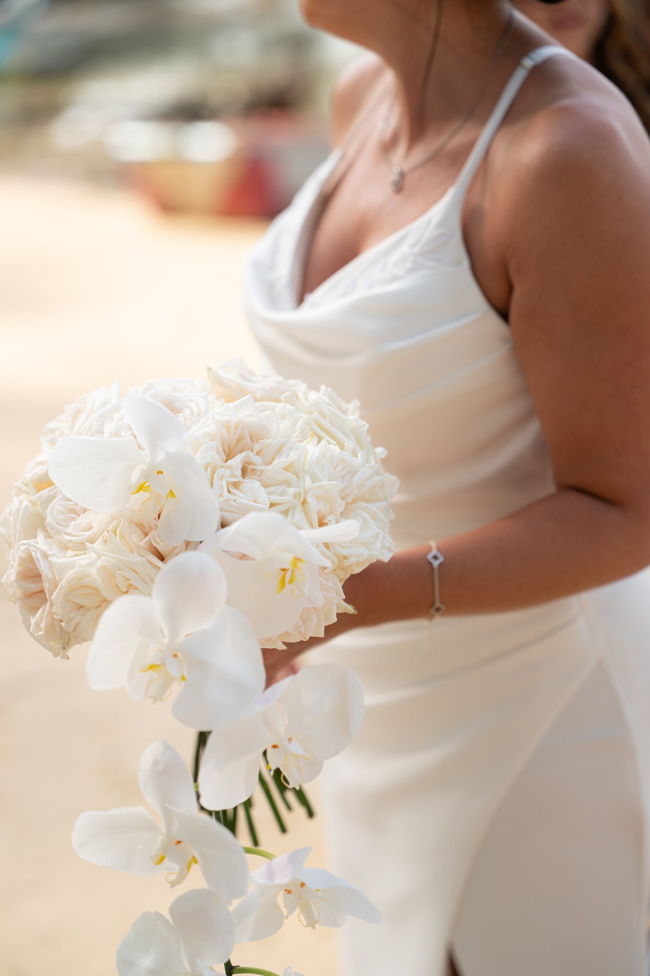 Jade's bridal bouquet of white peonies held close, tied with a soft ribbon