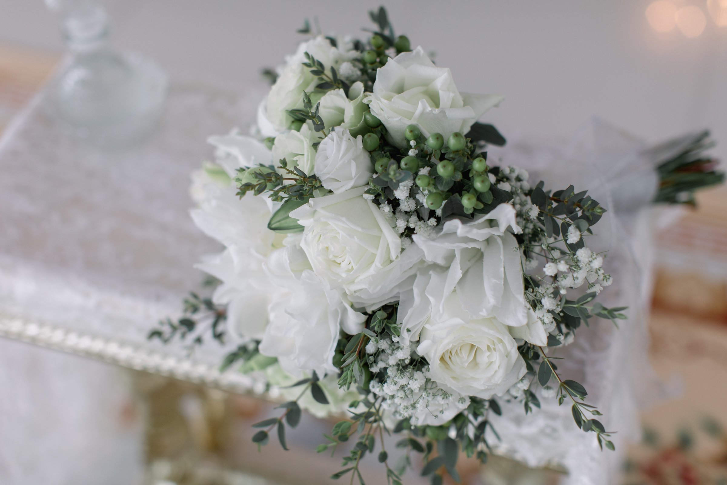White and pale rose bridal bouquet with soft greenery — the floral palette Anne chose