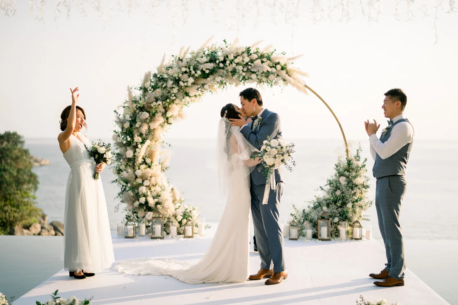 The first kiss under the circular white floral arch at Villa Aquila