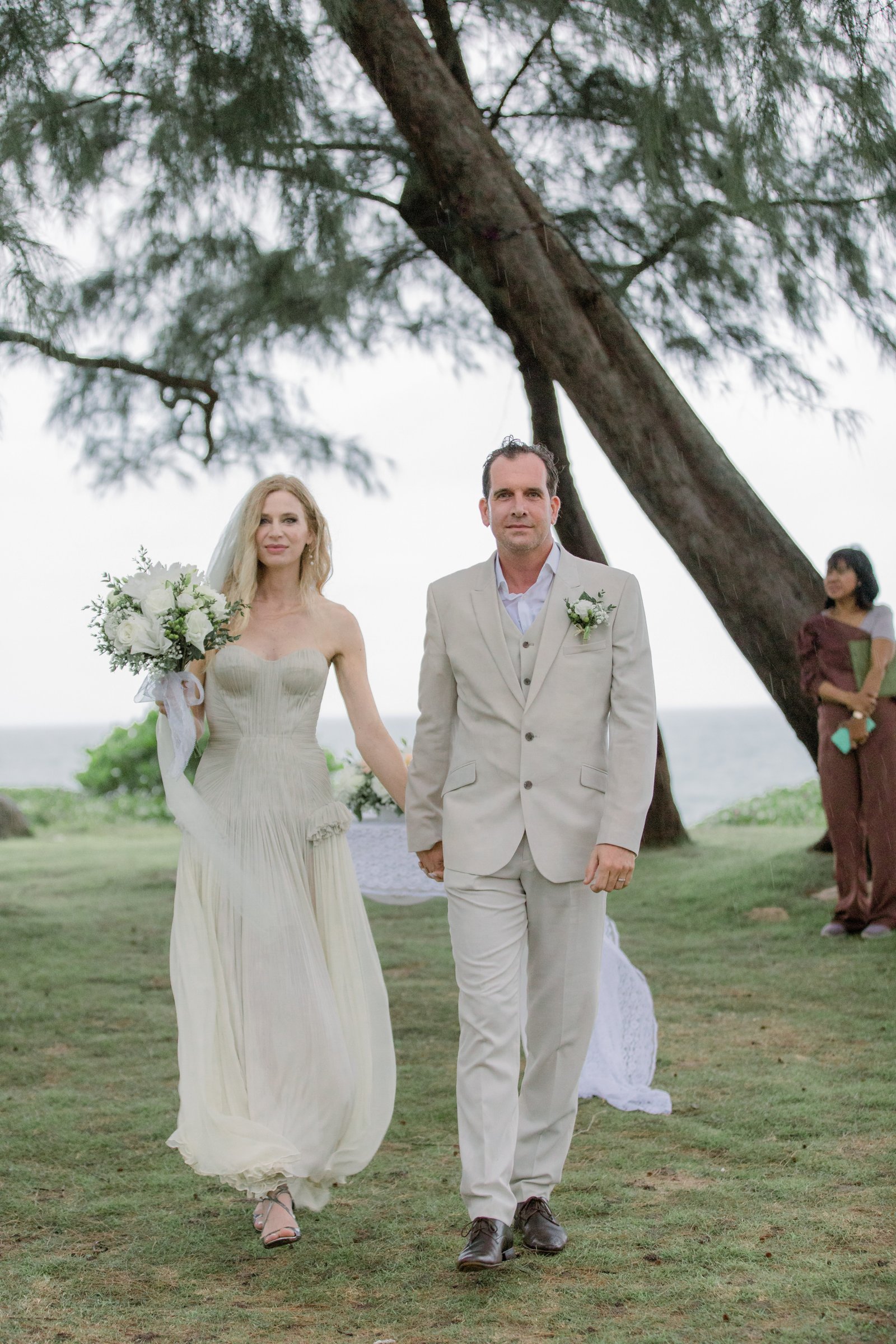 Anne and Jeremy walking together after their beach wedding ceremony at Anantara Mai Khao, Phuket