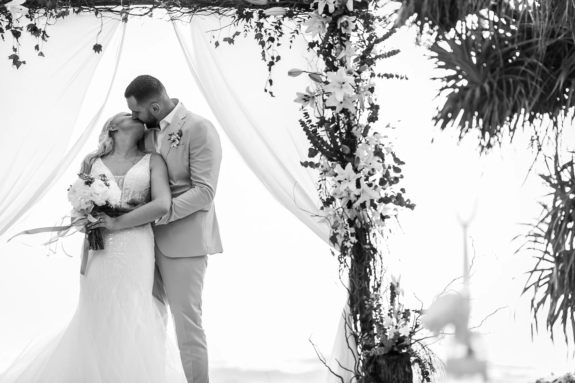 Bride and groom on Layan Beach at sunset after their Phuket wedding ceremony