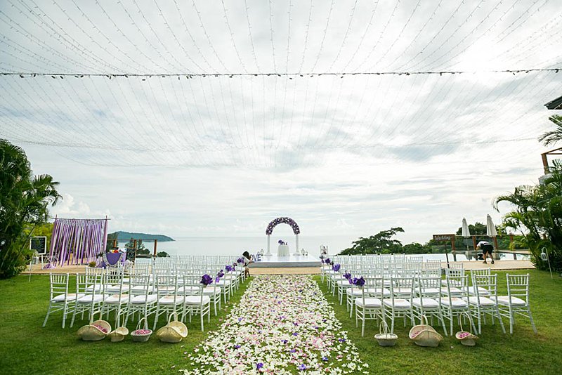 The pool-deck ceremony setup at Villa Aye — purple arch, petal aisle and Andaman Sea beyond