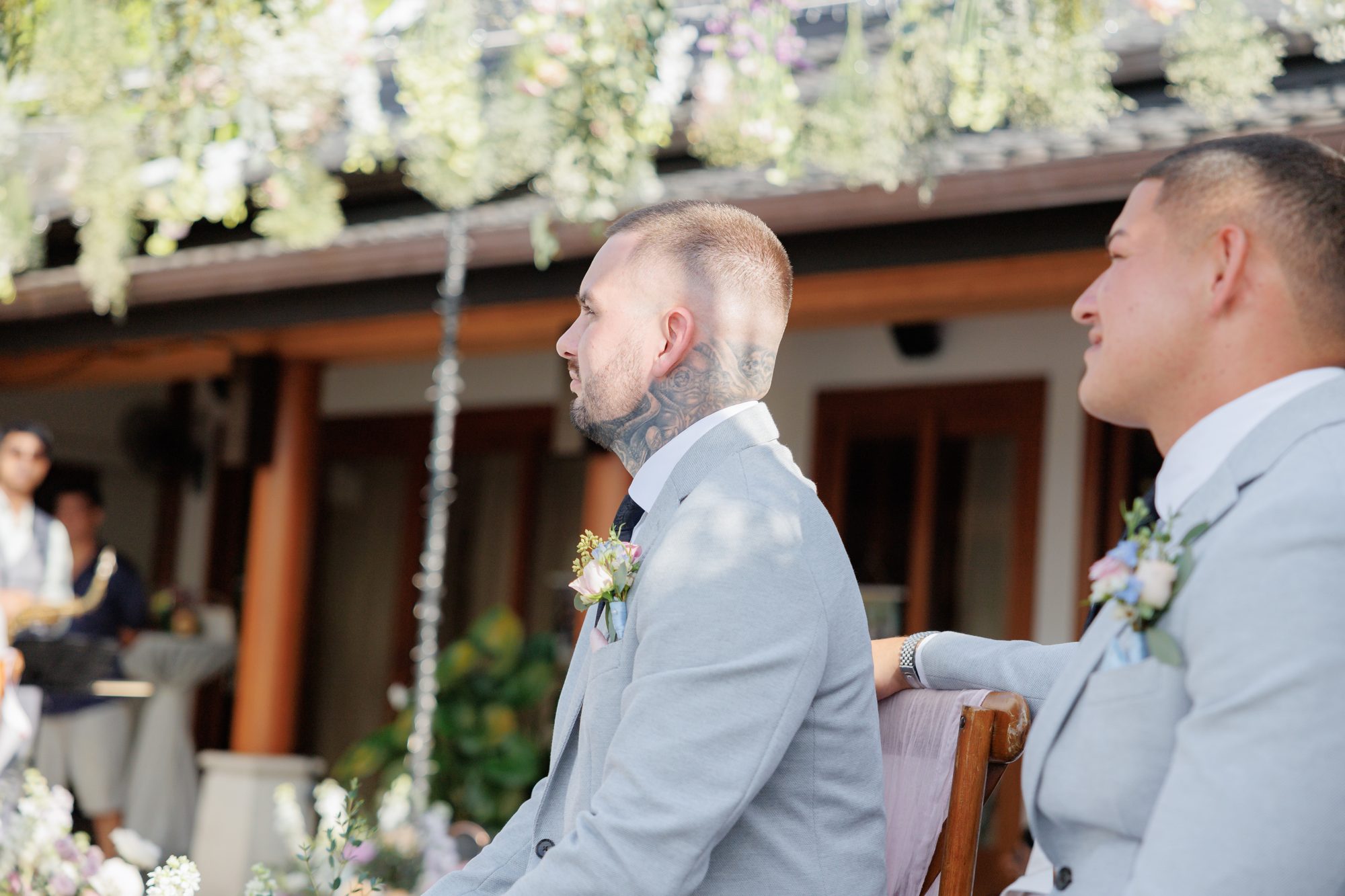 James at the ceremony with his best man beside him, waiting under the pastel floral arch at Villa Baan Phu Prana