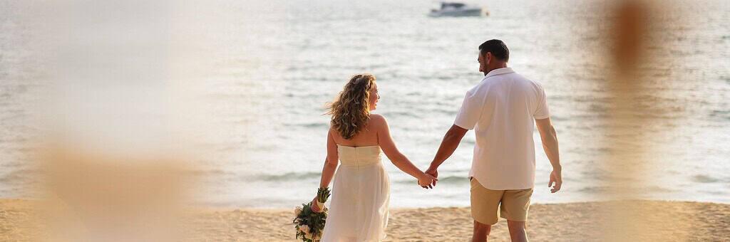 Couple walking after Phuket beach wedding elopement at sunset