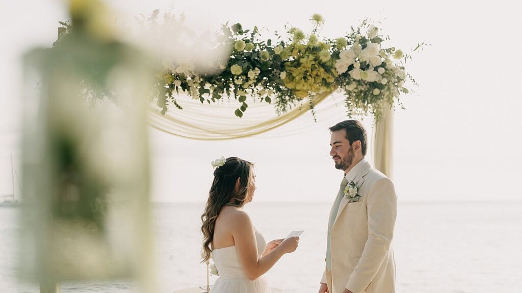Beach wedding elopement in Phuket couple ceremony with floral arch on tropical beach